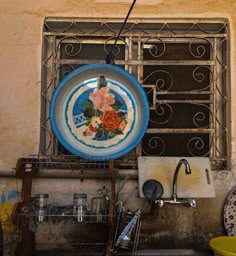 a blue and white plate sitting on top of a metal rack next to a sink