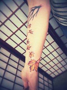 a woman's arm with leaves on it