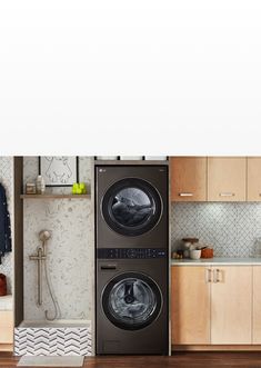 a washer and dryer in a room with wooden cabinets on the wall, next to a sink