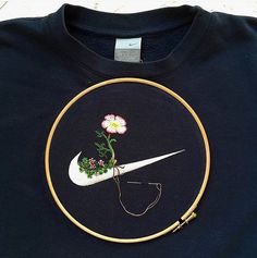 a black t - shirt with a white nike logo and flowers on it's back