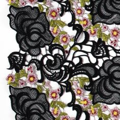 black lace with pink flowers and green leaves on white background, cut out from the fabric