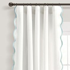 white curtains with scalloped edges hanging on a curtain rod