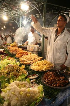 a man standing in front of a buffet filled with lots of different types of food