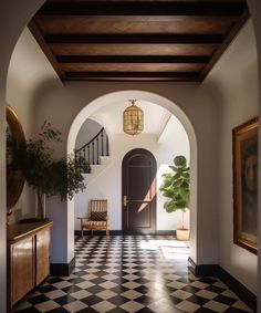 an archway leading into a foyer with black and white checkered flooring on the walls