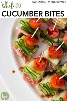 a white plate topped with cucumber bites covered in veggies