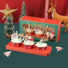 three christmas cupcakes sitting on top of a table next to a deer figurine