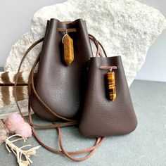 "Vegan Eco Leather Medicine Bag, Shaman Bag or Amulet Pouch to wear around your neck-or hang in your Car! Perfect for Ceremony or for Festival Wear. Dark Chocolate Faux Leather with a Tiger Eye Healing Stone Point. The Large size has a Double Terminated Stone! Unique and Beautiful Gift . A place for things that have Spiritual Meaning for you-like that pretty rock your 3 year old gave you.... Two Choices: Small:3 3/4\"deep 2 3/4\"wide Large:5 1/4\"deep 4\"wide BUY ANY 4 MEDICINE BAGS(VEGAN LEATHE Rectangular Faux Leather Bags With Card Slots, Rectangular Faux Leather Bag With Card Slots, Leather Shoulder Bag Pouch, Portable Leather Shoulder Pouch, Leather Shoulder Bag As Gift, Faux Leather Crossbody Bag Gift, Faux Leather Crossbody Bag For Gift, Portable Pouch Shoulder Bag As Gift, Faux Leather Shoulder Bag Perfect As A Gift