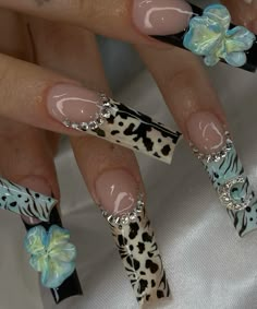 a woman's nails with leopard print and bows on them, decorated with fake flowers