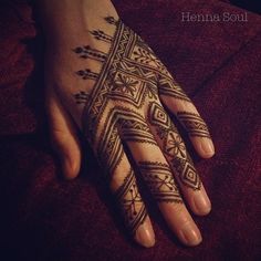 a woman's hand with henna tattoos on it