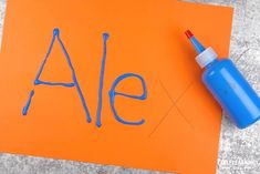 an orange piece of paper with the word ale written on it and a blue marker next to it