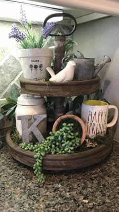 three tiered tray with plants and letters on it