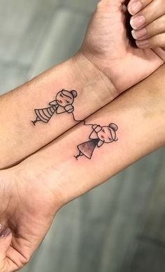 two people holding hands with tattoos on their arms and one has a small dog in the middle