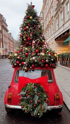 an old red car with a christmas tree on top