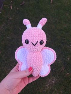 a pink and white crocheted stuffed animal with big eyes on it's face