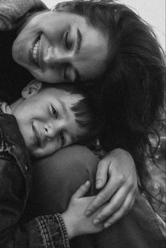 a woman and child hugging each other in black and white