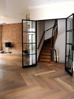 an empty room with wooden floors and glass doors that lead to the second floor area