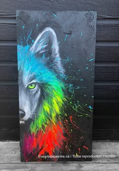 a painting of a wolf with multicolored paint splattered on it's face