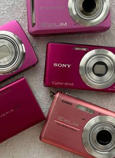 four pink digital cameras sitting next to each other