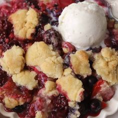 a white plate topped with blueberry cobbler and ice cream on top of it