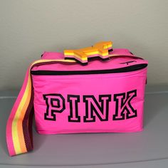 a pink lunch bag with the word pink on it and a yellow ribbon around the strap