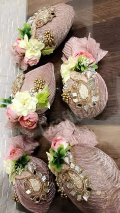 four pink shoes with flowers and pearls on them