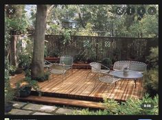 a wooden deck surrounded by plants and trees