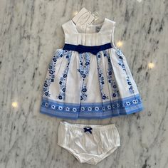 Super Sweet Baby Sleeveless Dress By Mayoral. It Has A White Bodice With Blue Flowers On The Skirt Portion Of The Dress. There Is A Blue Band Around The Waist With A Bow In The Front. It Is Lined And So The Little Skirt Is Full And There Are Matching Bloomers. Buttons Up The Back. Part Of Mayoral's Infant Line And The Sizing Is European. They Do More Size Ranges Than We Do Here In The Us. It Goes Like This 0-1m=Newborn, 1-2m= 0-3m 2-4m= 3m, 4-6m=6m, 6-9m= 9m, And Then 12m. I Am Listing The Us Si Summer Cotton Sets For Dress-up, Cotton Summer Dress-up Sets, Summer Cotton Dress-up Sets, Cute Blue Sets For Baptism, Blue Cotton Dress For Baptism, Cute Blue Baptism Set, Blue Summer Dress For Baptism, Spring Dress-up Sets In White, White Dress-up Sets For Spring