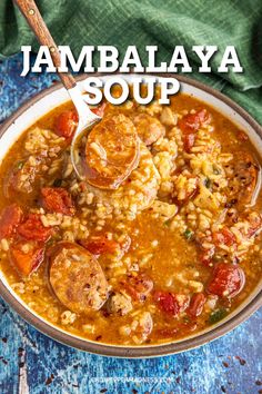 a bowl of jambala soup with sausage, tomatoes and rice on the side