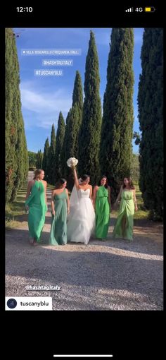 a group of women walking down a road next to trees