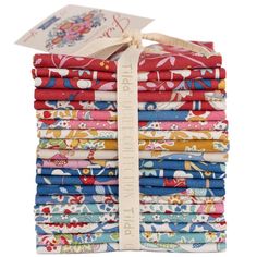 a stack of colorful fabric with a white ribbon