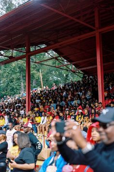 a group of people standing around each other in front of a crowd at a sporting event