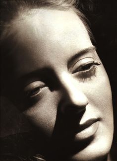 a black and white photo of a woman's face with her eyes half closed