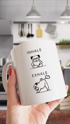 a person holding a coffee mug in their hand that says inhale and exhale