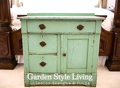 an old green dresser is sitting in front of a bed