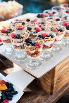 desserts are arranged in small glass dishes on a wooden table next to other food items