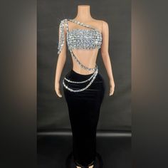 a mannequin is dressed in black velvet with silver beading and beads on it