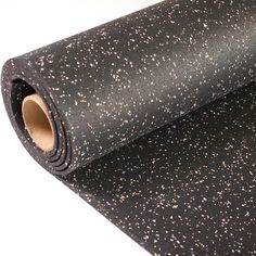 black and white speckled paper on a white surface with a roll of tape next to it