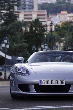 a silver sports car driving down the road