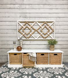 a white bench with wicker baskets on it and a wall mounted shelf behind it