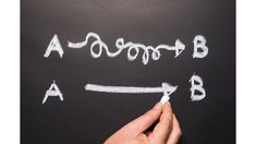 a hand writing on a blackboard with white chalk