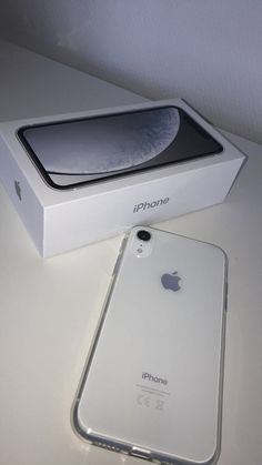 an iphone is sitting on the table next to its box