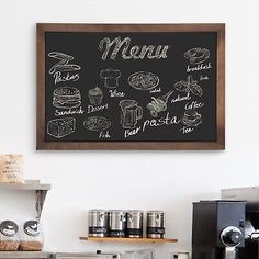 a chalkboard menu hanging on the wall above a coffee shop counter with pastries and other items