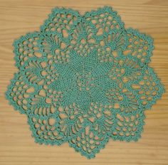 a crocheted doily on a wooden surface