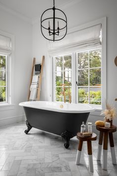 a bathroom with a claw foot tub and two stools