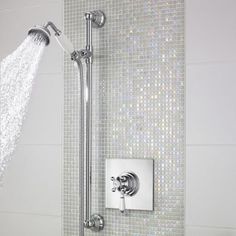 a shower head with thermostaer and faucet in front of it