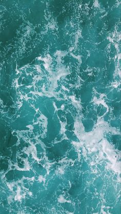 an aerial view of the ocean with waves