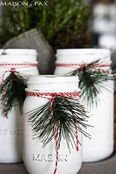 three mason jars with pine needles tied to them