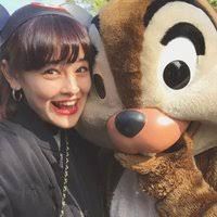 a woman standing next to a large stuffed animal