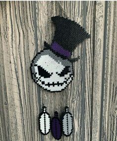 two beaded halloween decorations hanging on a wooden wall