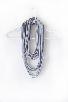 a gray scarf hanging on a white hanger